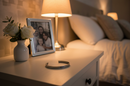 Loved cuff bracelet on bedside table with framed family photo